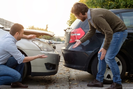 Two men arguing after a car accident.